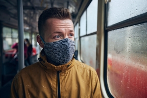 čovjek nosi zaštitnu  masku u javnom prijevozu