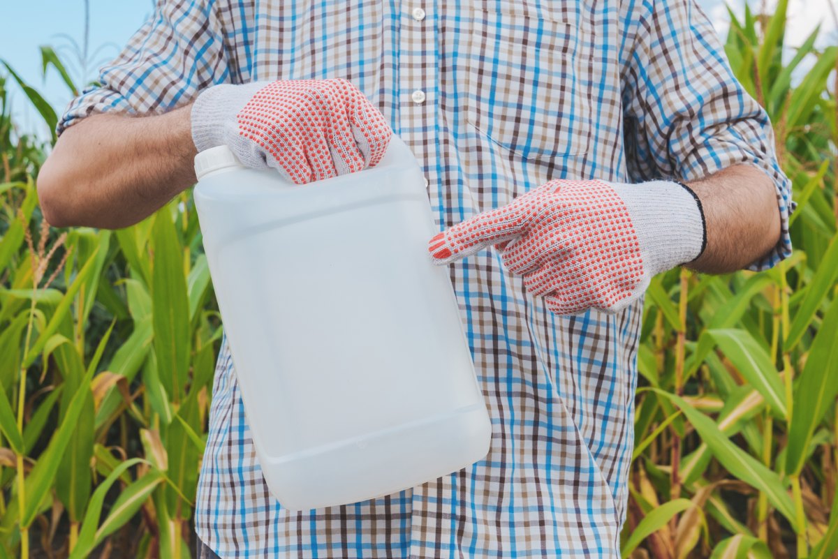 farmer holding pesticide chemical jug in 2